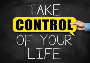 Take control of your life / written on Blackboard with man holding control sign